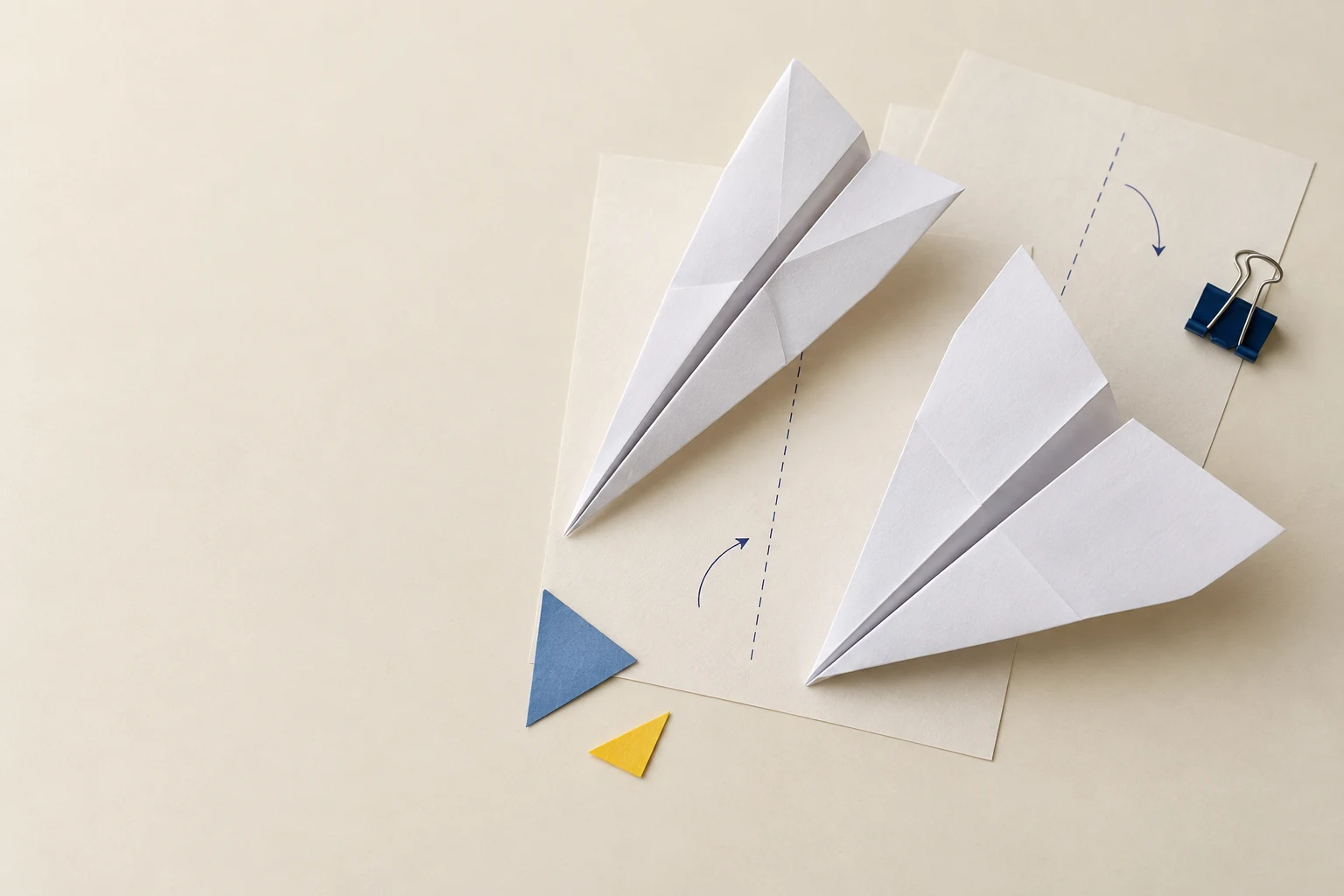Paper planes and illustrated template sheets arranged on a workbench